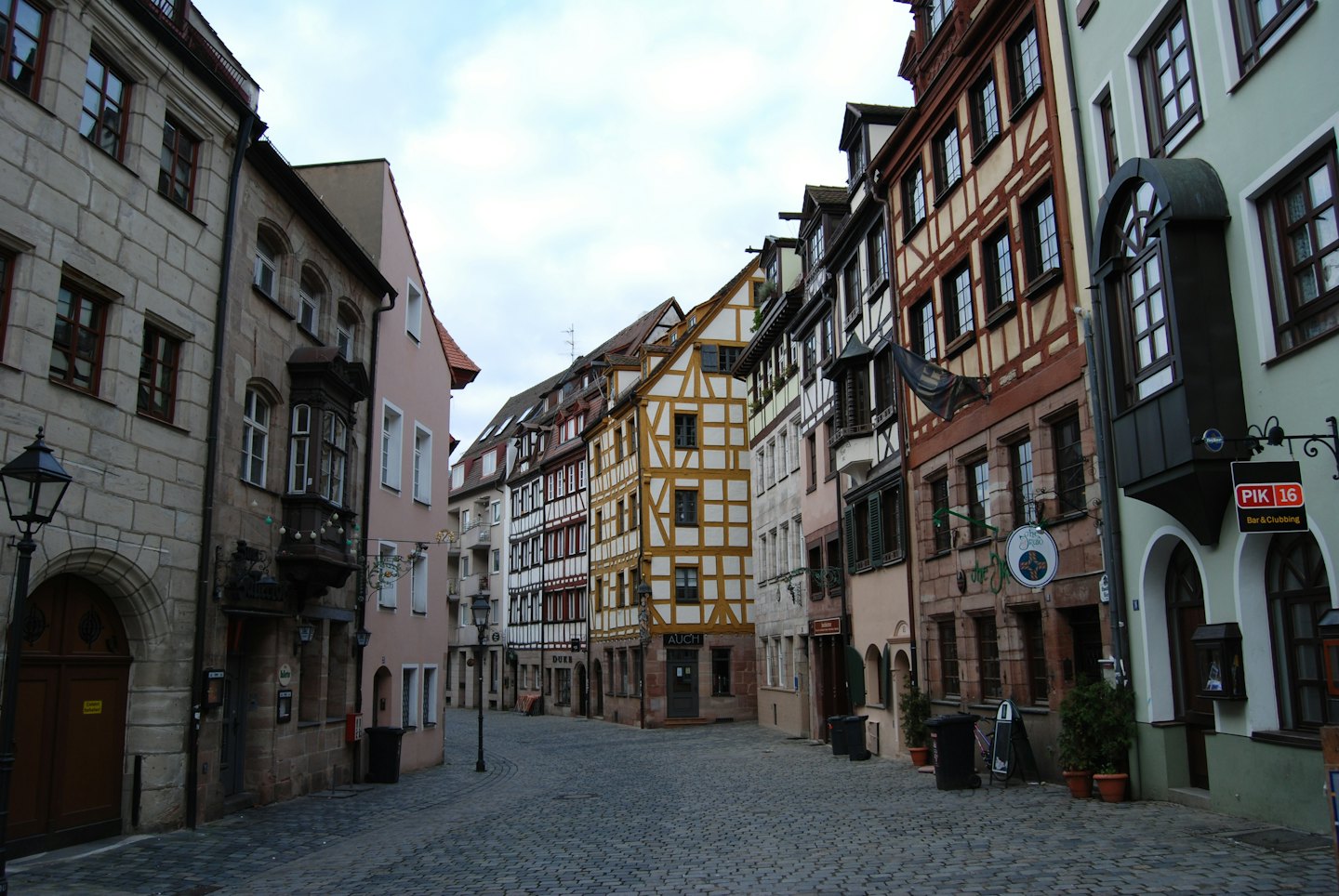 Empty cobblestone street lined with historic European buildings.