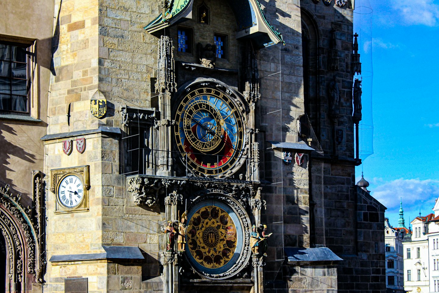 Intricate Prague Astronomical Clock dials mounted on a historic stone building.