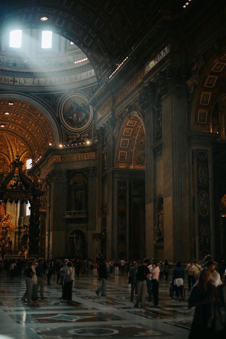 Visitors walk across the marble floor of an ornate cathedral.